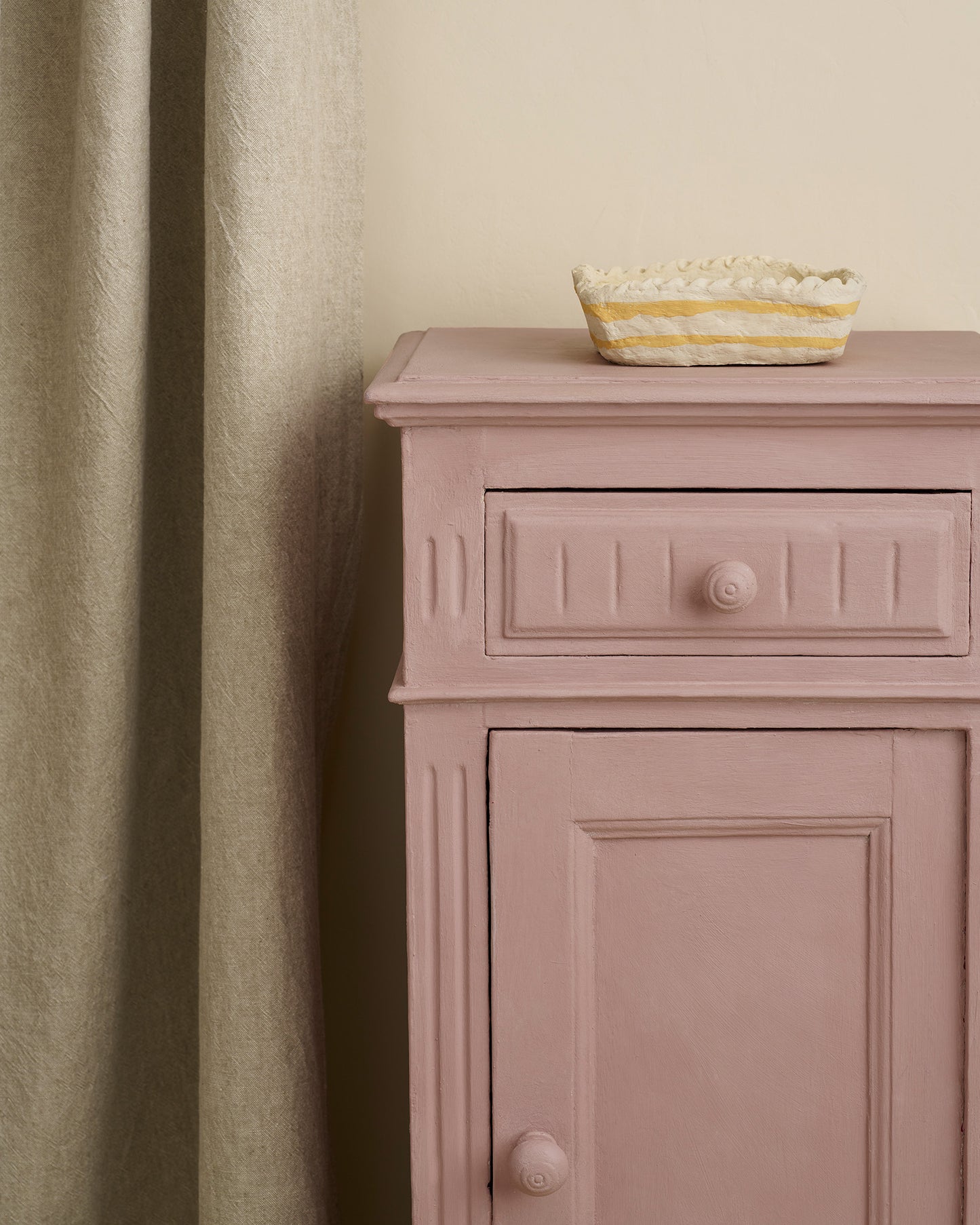 Jaipur Pink Annie Sloan Chalk Paint painted cabinet with a glass bowl on top against a beige wall