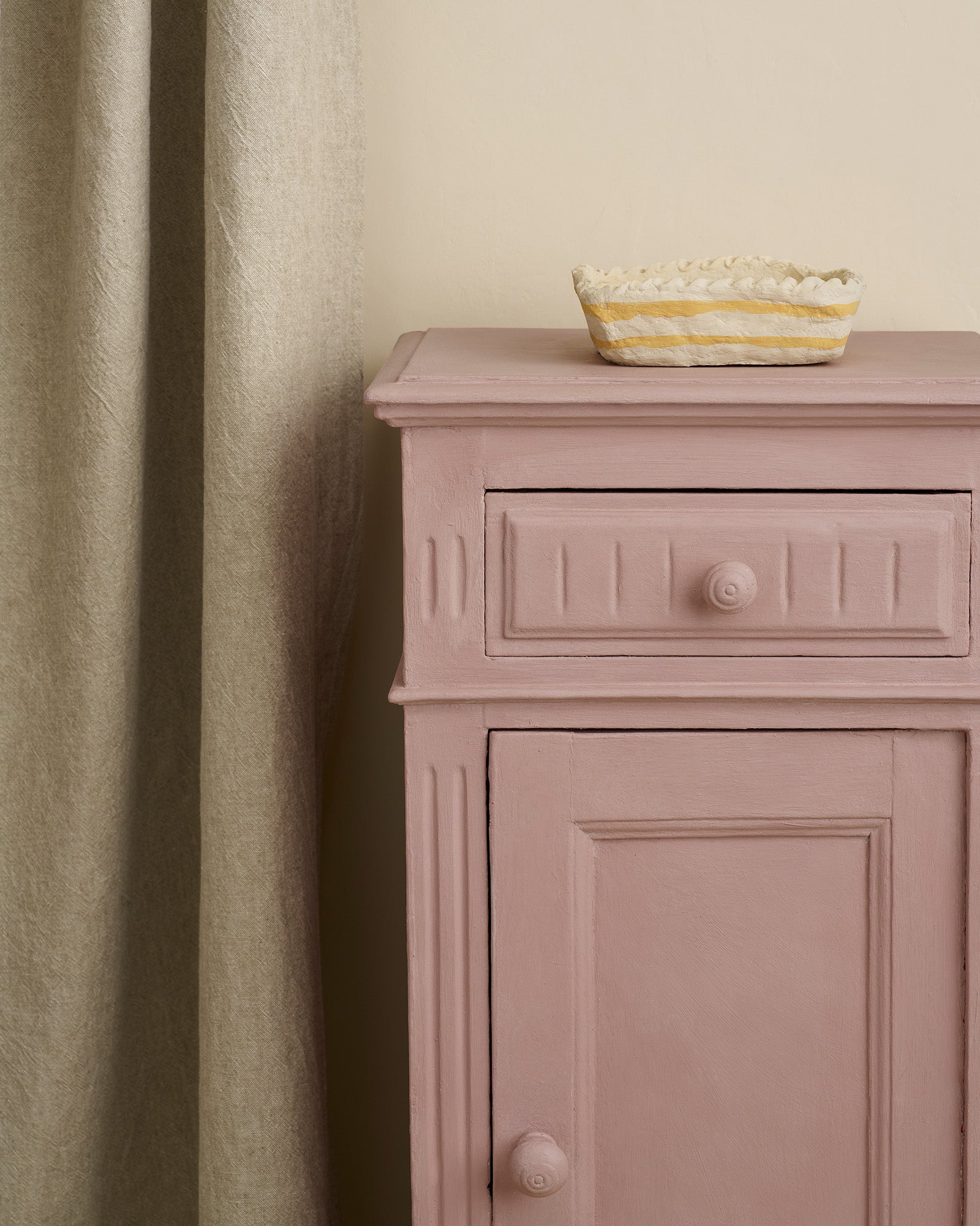Jaipur Pink Annie Sloan Chalk Paint painted cabinet with a glass bowl on top against a beige wall